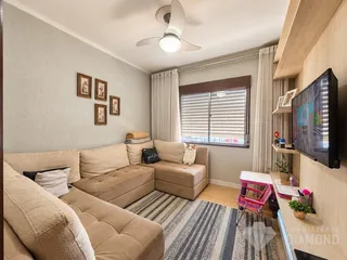 Sala de estar com sofá e janela em um imóvel no Brasil.