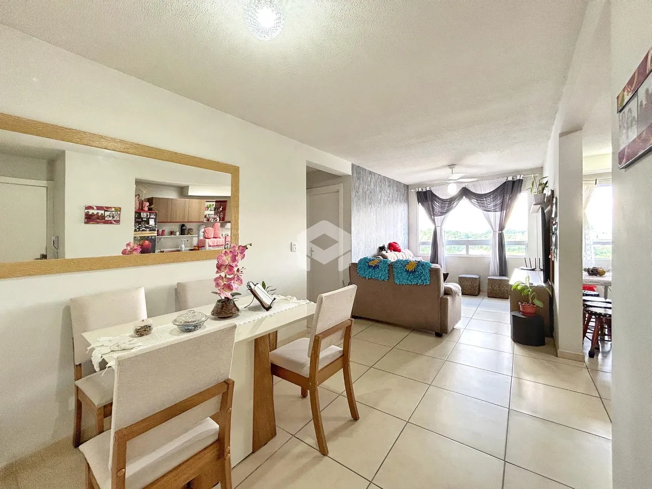 Sala de estar e jantar com piso de cerâmica clara e móveis de madeira.