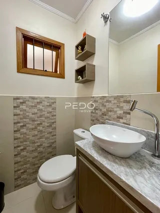 Foto de um banheiro com revestimento de azulejos e bancada de mármore.