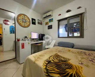 Quarto com cama e decoração de parede em uma residência.