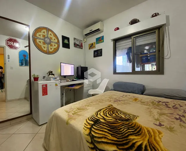 Quarto com cama e decoração de parede em uma residência.