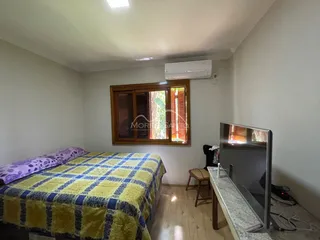 Quarto com cama e janela de madeira.