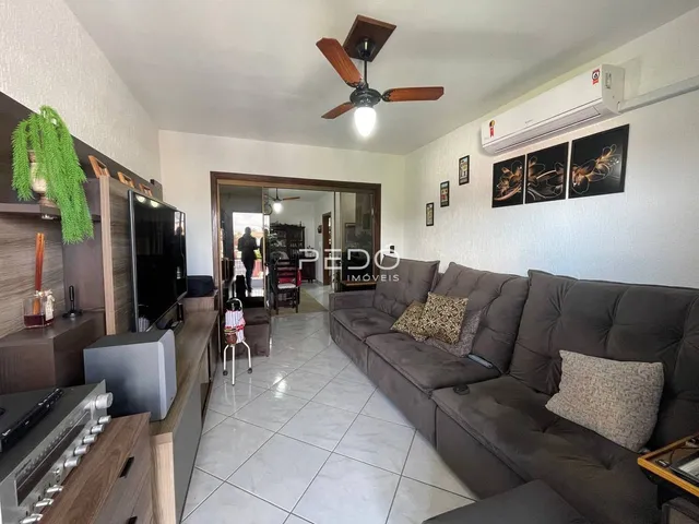 Sala de estar com sofá e televisão em um imóvel no Brasil.
