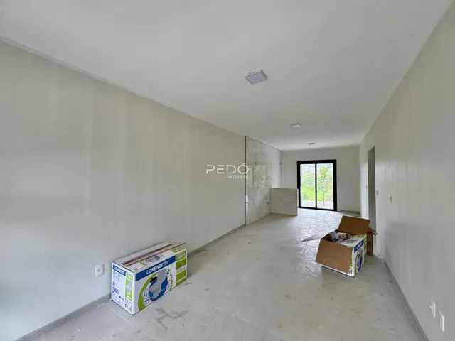 Interior de um corredor longo com paredes brancas e piso claro.