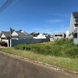Foto da fachada de uma propriedade com gramado e cerca.