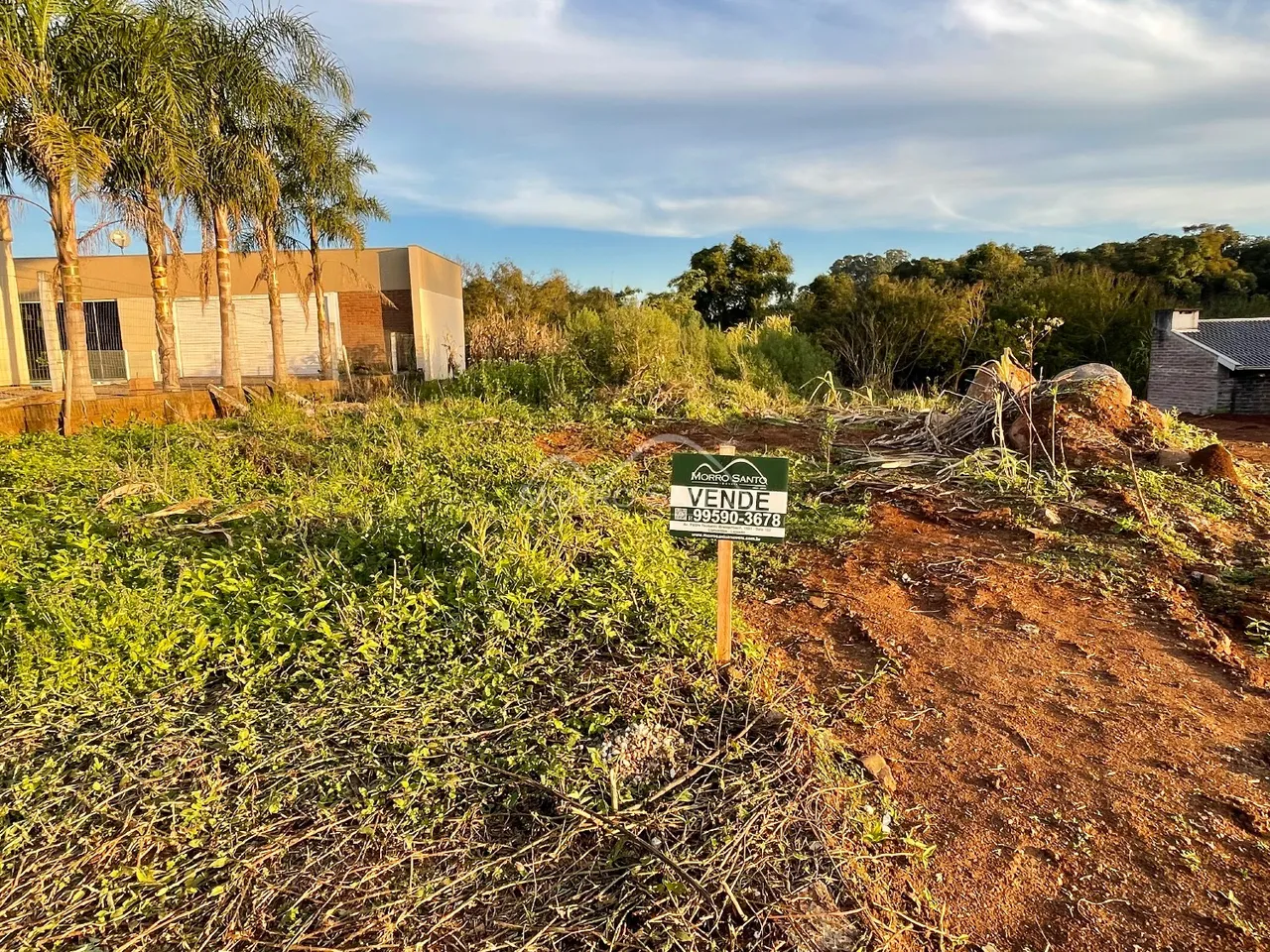 Vista externa de um terreno com vegetação densa e placa de venda em Lajeado, Brasil.