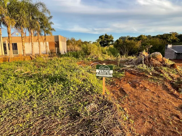 Vista externa de um terreno com vegetação densa e placa de venda em Lajeado, Brasil.