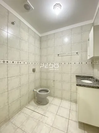 A foto mostra um ambiente interno com revestimento de cerâmica e um vaso sanitário.