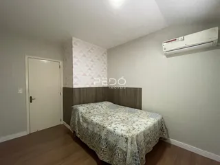 Quarto com cama e parede decorada em Lajeado.