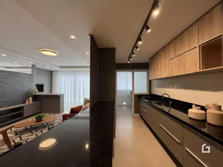 Ambiente moderno de sala de estar e cozinha com ilha.