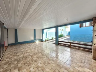 Área externa com piso de cerâmica e vista para a água.