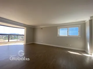 Sala ampla com piso de madeira e vista para a paisagem.