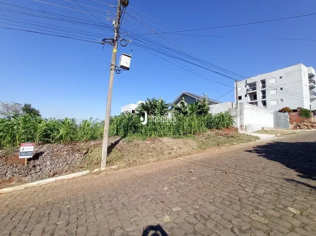 Vista externa de um terreno com vegetação e uma estrutura de concreto ao fundo.