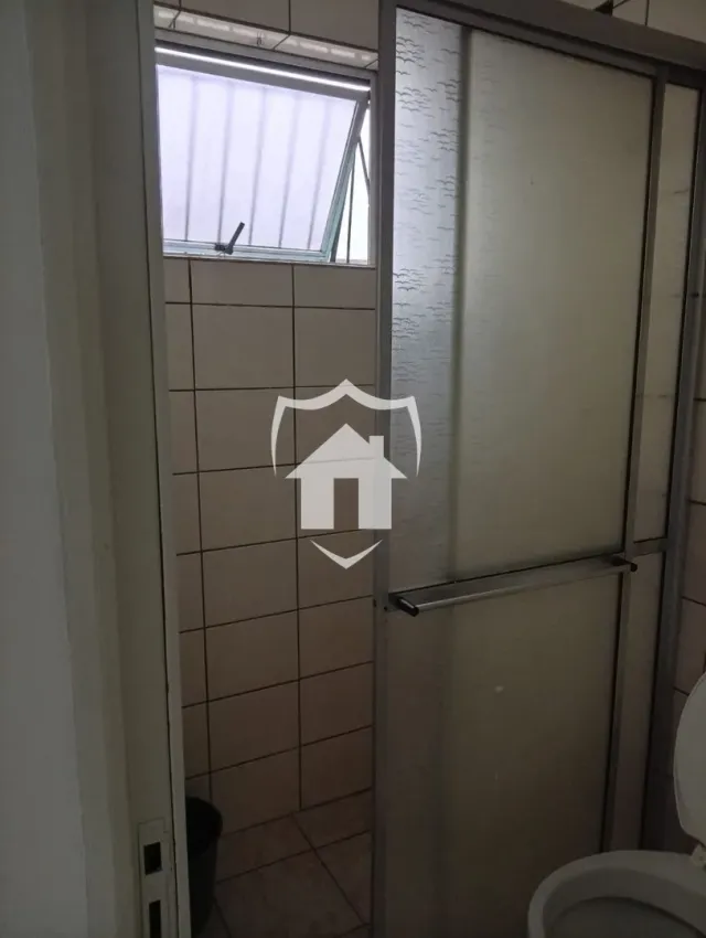 Foto de um banheiro com revestimento de azulejos claros.