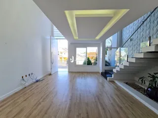 Ambiente interno com piso de madeira clara e teto branco.
