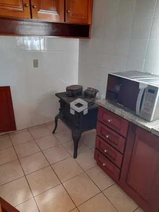 Foto de uma cozinha com piso de cerâmica e armários de madeira.