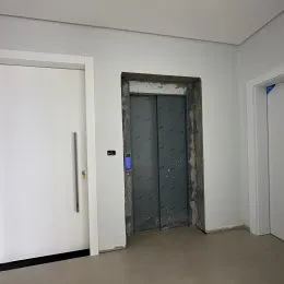 Hall de entrada com paredes brancas e porta.