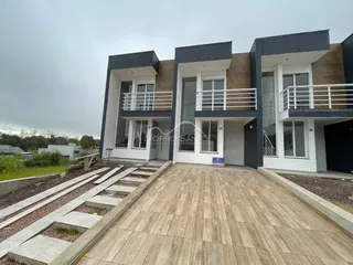 Fachada moderna de uma casa em Lajeado, Brasil, com detalhes em cinza escuro e branco.