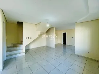 Imagem de um ambiente interno com piso de cerâmica e escadaria em uma residência.