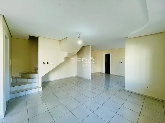 Imagem de um ambiente interno com piso de cerâmica e escadaria em uma residência.