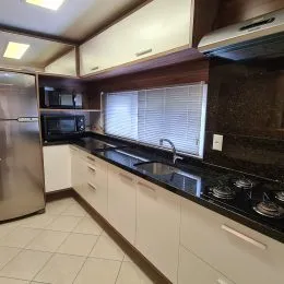 Foto interna de uma cozinha com armários e bancadas.
