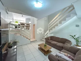 Sala de estar com escadaria e sofá em um apartamento.