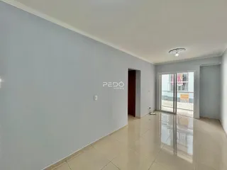 Espaço interno de uma residência com piso de cerâmica e portas de vidro.