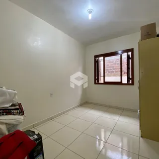 Vista interna de um corredor com piso de cerâmica e paredes brancas.