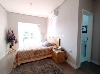 Quarto com cama e piso de madeira em um imóvel no Brasil.