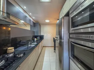 Vista da cozinha moderna com armários e eletrodomésticos de aço inoxidável.