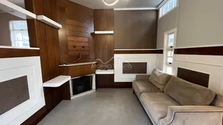 Sala de estar com painel de madeira e sofá em ambiente interno.