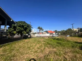 Vista externa da propriedade com grama seca e cerca.