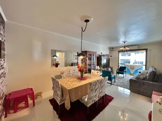 Sala de estar com mesa de jantar e sofá em ambiente claro.
