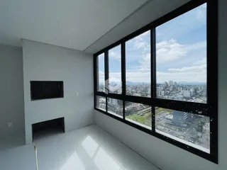 Ambiente interno com grande janela que oferece vista da paisagem urbana.