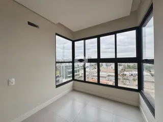 Uma sala com grandes janelas que oferecem uma vista da paisagem urbana.
