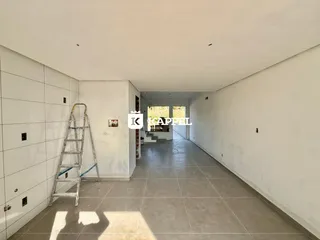 Corredor longo e branco com piso de cerâmica.