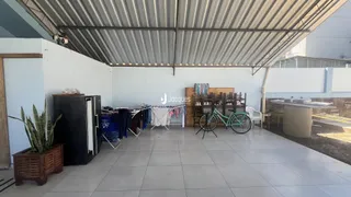 Área externa coberta com piso de cerâmica e roupas penduradas.