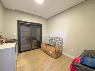 Interior de uma sala com piso de madeira e porta de correr.
