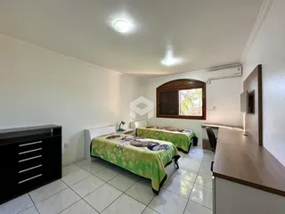 Quarto com duas camas de solteiro e janela em um imóvel.