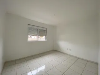 Foto de um cômodo com piso de porcelanato claro e janela.