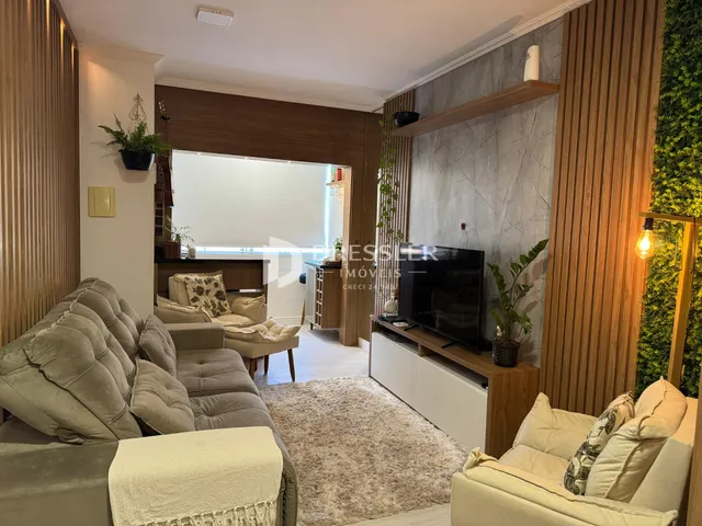 Sala de estar com sofás e decoração em madeira clara.