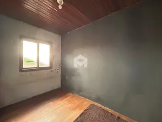 Foto de um cômodo interno com piso de madeira e janela.