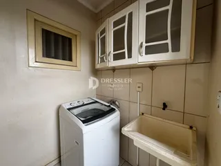 Foto de um ambiente interno mostrando uma máquina de lavar e bancada.