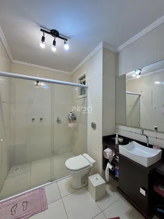 Banheiro com box de vidro e pia moderno.