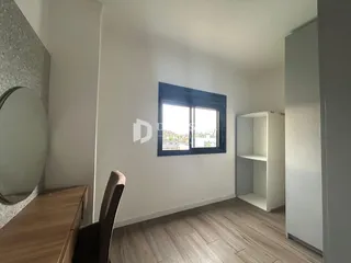 Sala de estar com piso de madeira e janela.