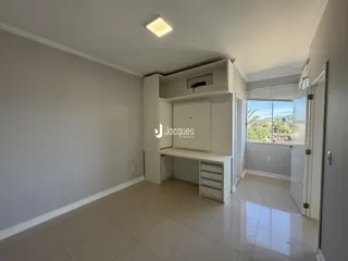 Interior de uma sala com paredes brancas e piso claro.