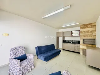 Sala de estar com sofá e poltrona em ambiente claro.