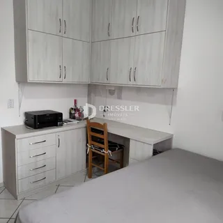 Uma vista de um quarto com armários e uma cama em um imóvel no Brasil.