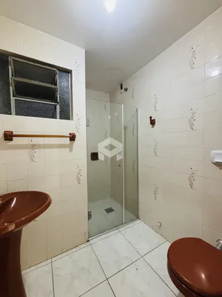 Interior de um banheiro com azulejos brancos e piso claro.
