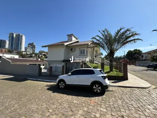 Fachada de uma residência em Lajeado, Brasil, com um carro estacionado na frente.